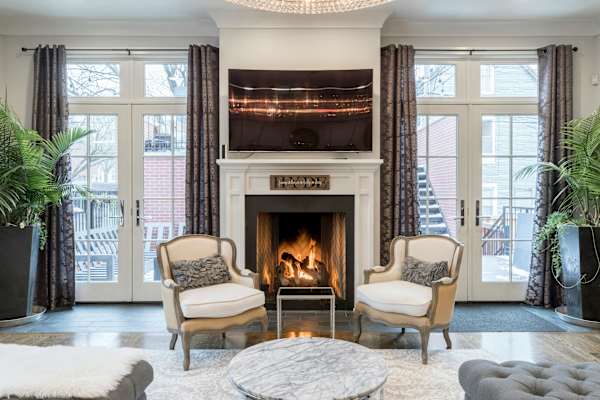 A living room with a fireplace and two chairs.